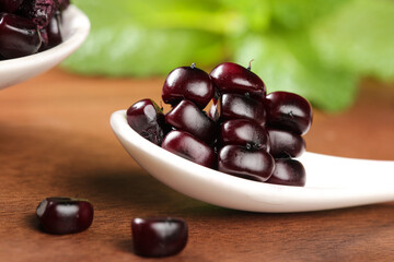 Xishuangbanna Purple Sticky Corn Kernels from Yunnan China in White Spoon on Wood Table