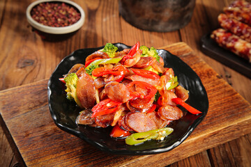 Cantonese Style Stir-Fried Chinese Sausage with Broccoli and Peppers on Wooden Table