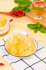 Yellow Rock Candy Sugar Cubes with Tea and Mint Leaves on Wooden Table