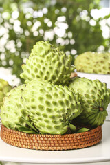 Obraz premium Fresh Custard Apples Sugar Apples in Wicker Basket Taiwan Tropical Fruit with Green Bokeh Background