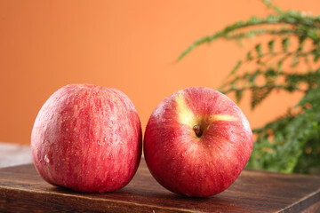 Fresh Red Striped Fuji Apples on Wooden Table with Tropical Background