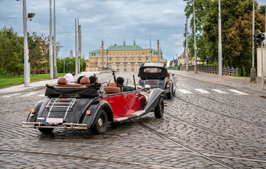 Prague, Czech Republic, August 6, 2023. Vintage cars for rent for tourists exploring the city in an...