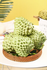 Fresh Custard Apple Sugar Apple Fruits in Wicker Basket on White Table Yellow Background