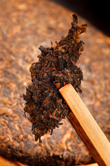 Ancient Puer Tea Leaves on Wooden Spoon - Traditional Chinese Fermented Tea with Rich Earthy...