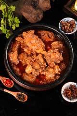 Spicy Oxtail Stew with Fresh Herbs and Traditional Spices Served in Black Pot