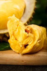Fresh Golden Durian Fruit Opened Showcasing Creamy Flesh and Shell on Wooden Board