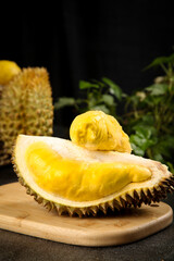 Fresh Golden Durian Fruit Cut Open Showing Deep Yellow Flesh on Wooden Board