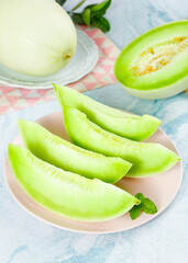 Fresh Green Honeydew Melon Slices with Mint on Rustic Background