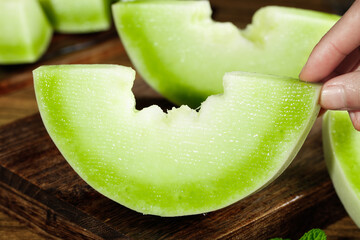Fresh Jade Green Honeydew Melon Slice Being Held Over Wooden Cutting Board Shandong China