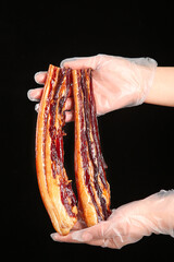 Smoked Pork Bacon Strips Held in Gloved Hands - Traditional Cured Meat Food Preparation