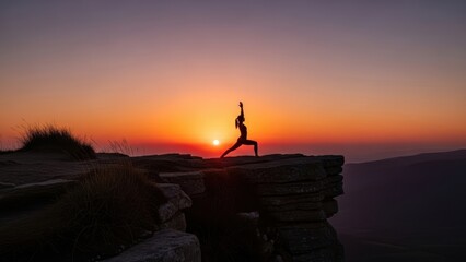A woman's silhouette in a yoga pose on a mountain ledge during a vibrant sunset.