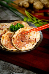 Delicious sliced pork belly buns with chopsticks on black plate - Asian cuisine indoor food photography