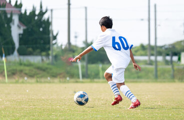 サッカーの試合をする中学生の男の子