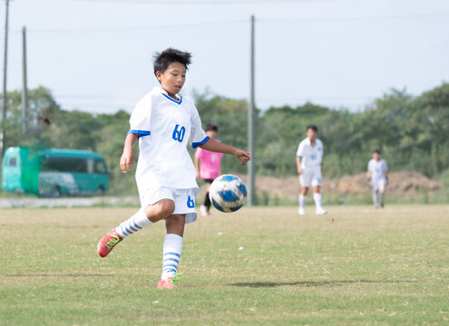 サッカーの試合をする中学1年生の男の子