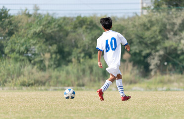 サッカーの試合をする中学生の男の子