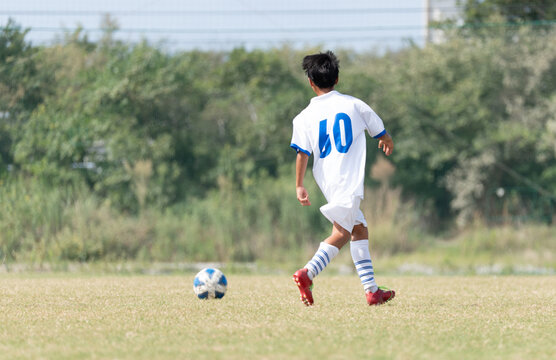 サッカーの試合をする中学生の男の子