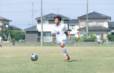 サッカーの試合をする中学生の男の子