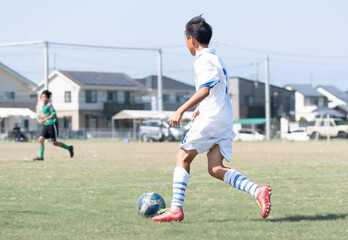 サッカーの試合をする中学生の男の子