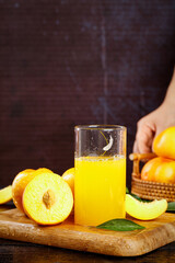 Fresh Peach Juice with Sliced Peaches on Wooden Board and Wicker Basket