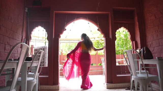 Young indian woman wearing pink saree dancing. Culture of india. People of Rajasthan.