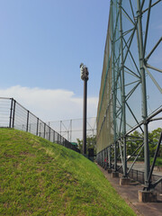 The floodlight stands in front of the steel structure that holds the safety net surrounding the...