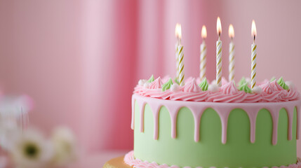 Mint and pink birthday cake with lit candles on pastel background.
