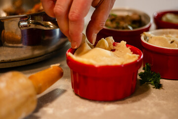Pinching pastry edges to seal turkey pot pie crust