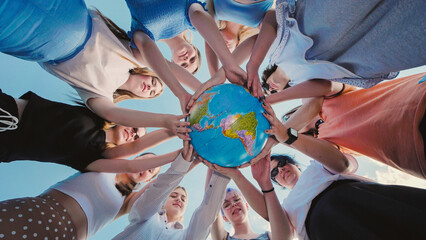 Group of school friends holding a globe, symbolizing global unity and care for the environment, promoting sustainability and responsibility towards earth