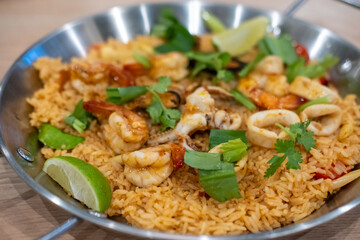 Seafood Tom yum fried rice, a dish of rice  with tom yum paste, garlic and chili fried with prawn, squid and mussel, served on a pan