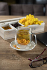 Refreshing herbal tea with dried flowers and spices on a wooden table