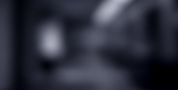 Abstract blurry dark gray background with soft light spots, creating a minimal mysterious ambience with subtle glowing highlights and elegant artistic depth.