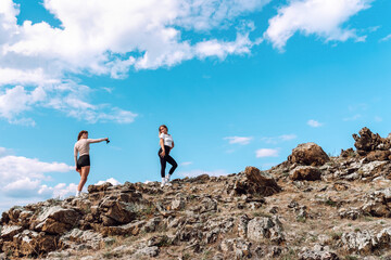 Obraz premium Friends exploring a rocky landscape together under the blue sky. Photo session in nature.