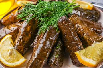 Delicious Turkish dish, stuffed grape leaves, on a stone table