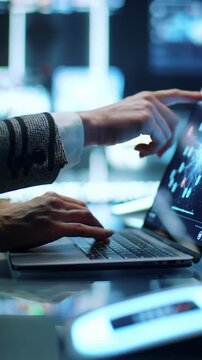 ECU video: professional hands in business casual attire typing on minimalist laptop, interacting with vibrant touchscreen, biometric scanner in high-tech workspace. Advanced technology concept
