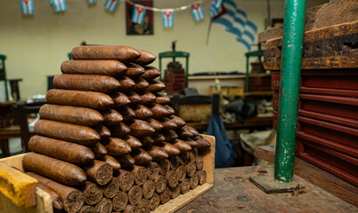Cuban cigars stacked in pyramid formation, highlighting artisan rolling techniques within...