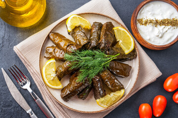 Delicious Turkish dish, stuffed vine leaves, on a black stone table