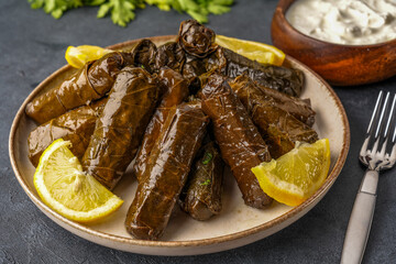 Delicious Turkish dish, stuffed vine leaves, on a black stone table