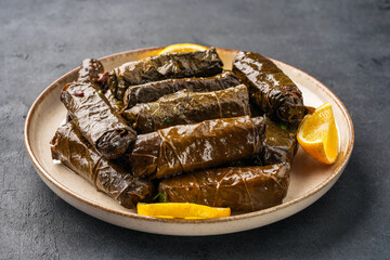 Delicious Turkish dish, stuffed vine leaves, on a black stone table