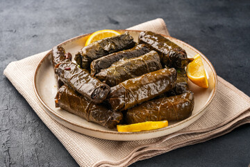 Delicious Turkish dish, stuffed vine leaves, on a black stone table