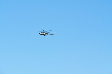 Obraz premium Helicopter flying in the blue sky, closeup of photo