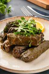 Delicious Turkish dish, stuffed vine leaves, on a black stone table