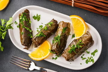 Delicious Turkish dish, stuffed vine leaves, on a black stone table