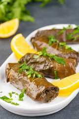 Delicious Turkish dish, stuffed vine leaves, on a black stone table