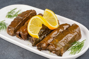 Delicious Turkish dish, stuffed vine leaves, on a black stone table