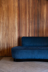 Modern waiting room with blue sofa and wooden wall