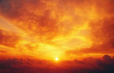 Bright sun glowing through vibrant orange and yellow clouds during a dramatic sunset or sunrise