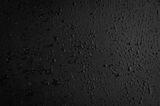 Drops of water on a black surface. The condensate. Top view. Free space.