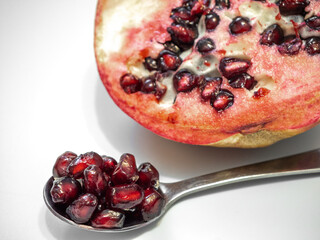 Scoop out the seeds from the halved pomegranate, scoop out the red seeds for juice on a spoon