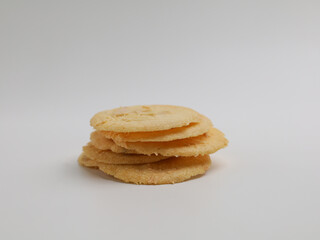 Almond crispy cookies stacked on white background