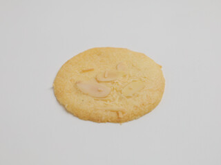 Almond crispy cookies stacked on white background
